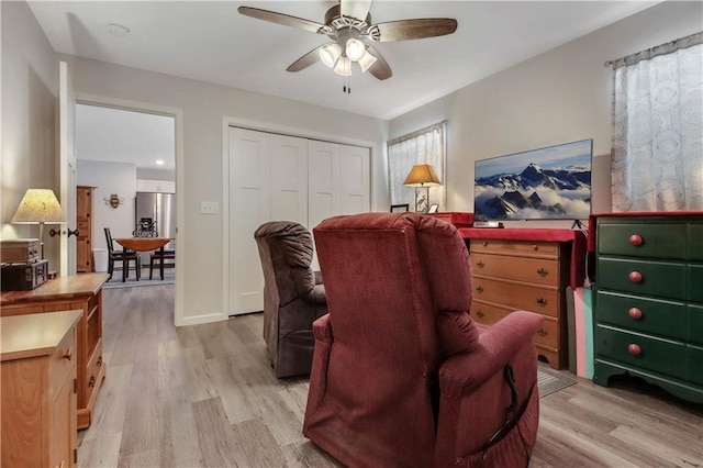 living area with light wood-type flooring and ceiling fan