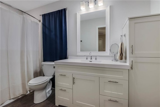 bathroom with hardwood / wood-style floors, vanity, and toilet