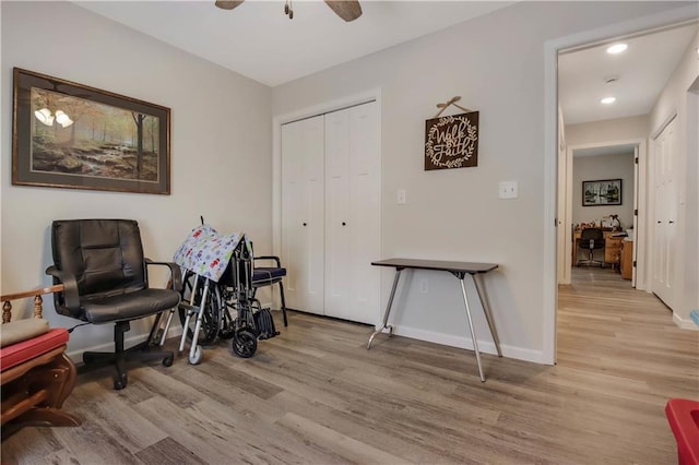 living area with ceiling fan and light hardwood / wood-style flooring