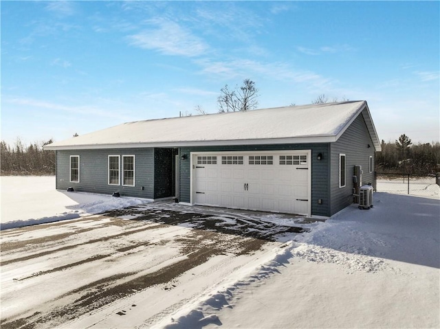 single story home featuring cooling unit and a garage