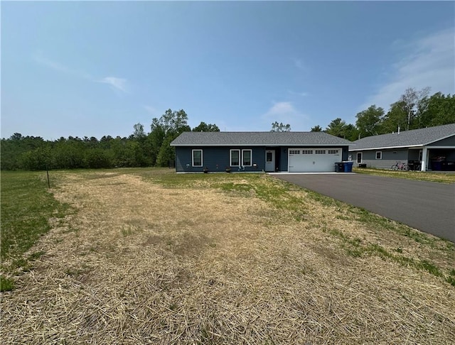 10004 Aspen Ln, Hayward, WI 54843 - ranch-style home with driveway, a garage, and a front lawn