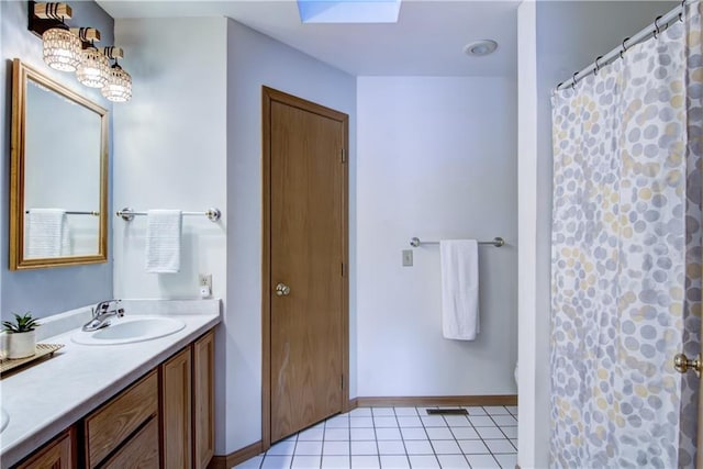 bathroom with a skylight, tile patterned flooring, vanity, and a shower with curtain