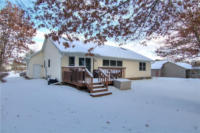 snow covered back of property featuring a deck