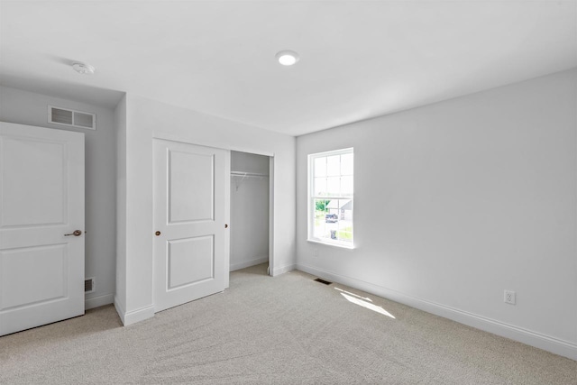 unfurnished bedroom featuring light colored carpet and a closet