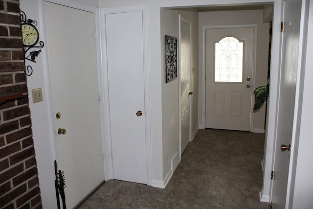 foyer featuring brick wall