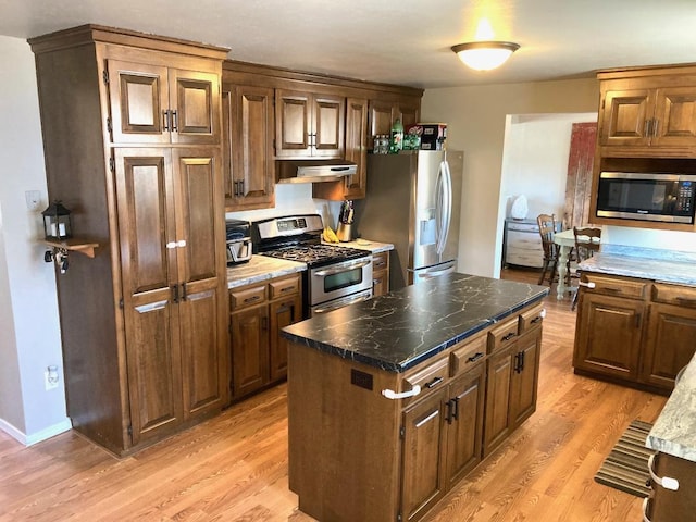 kitchen featuring stainless steel appliances, light hardwood / wood-style floors, and a center island