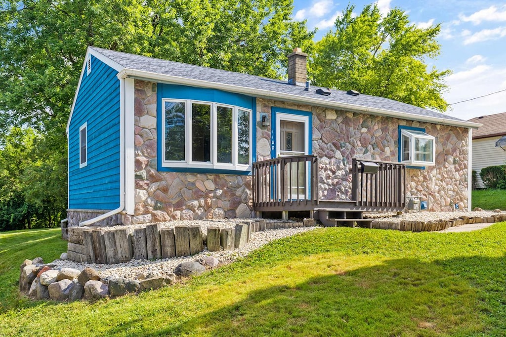 back of house with a deck and a yard