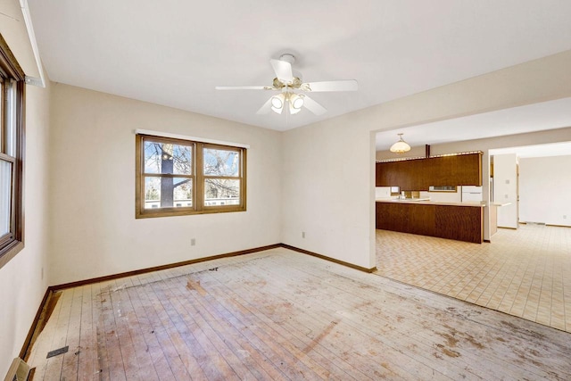 unfurnished living room with ceiling fan and light hardwood / wood-style floors