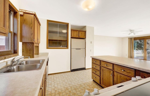 kitchen featuring white fridge, ceiling fan, and sink