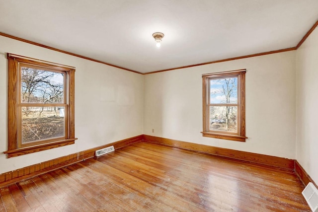 spare room featuring hardwood / wood-style flooring and crown molding