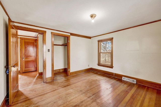 unfurnished bedroom with ornamental molding and light hardwood / wood-style floors