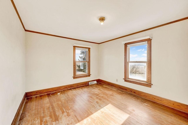 empty room with hardwood / wood-style floors and crown molding