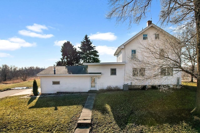 back of house with a yard and central air condition unit