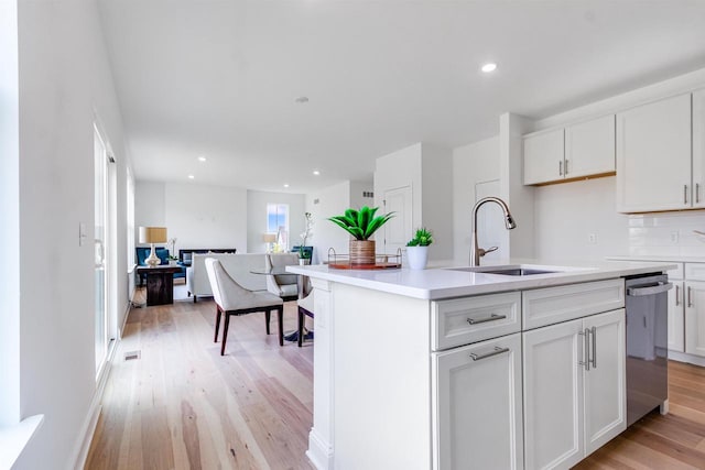 kitchen with dishwasher, a center island with sink, tasteful backsplash, white cabinets, and sink