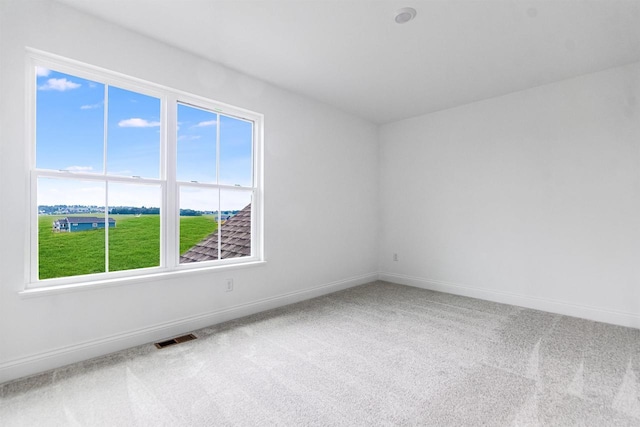 carpeted spare room featuring plenty of natural light