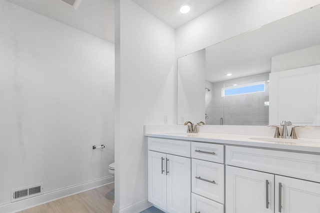 bathroom with toilet, an enclosed shower, and vanity