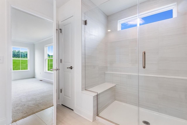 bathroom featuring tile patterned flooring, a shower with shower door, and ornamental molding