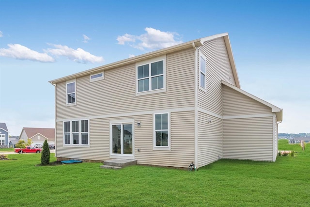 rear view of house featuring a lawn