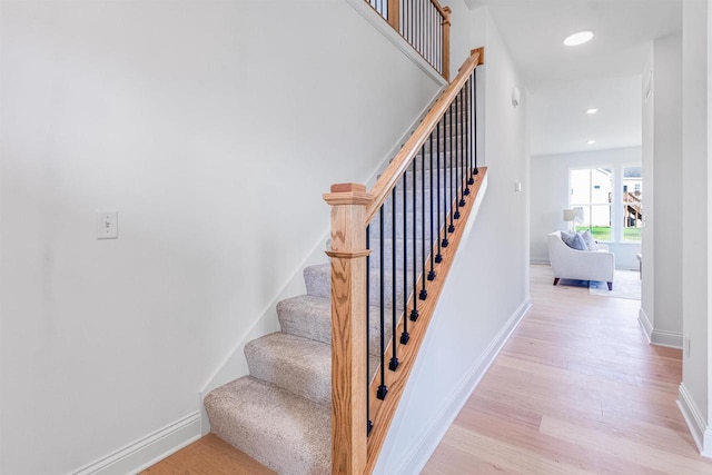 stairs featuring hardwood / wood-style floors