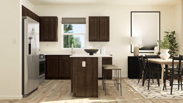 kitchen with appliances with stainless steel finishes, light wood-type flooring, a kitchen bar, and dark brown cabinets