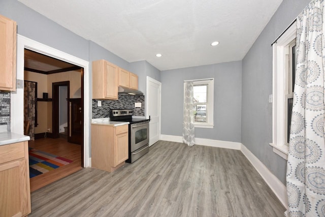 kitchen with electric range, light wood-type flooring, tasteful backsplash, and light brown cabinets