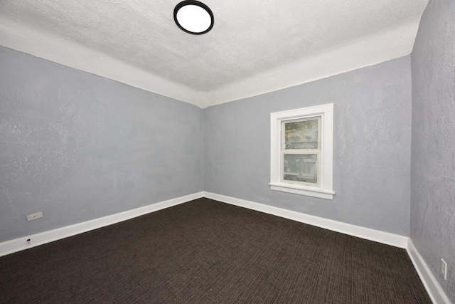 spare room with a textured ceiling and carpet