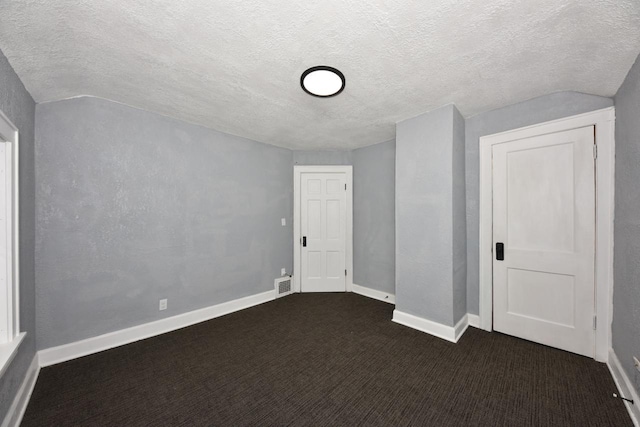 bonus room with lofted ceiling, a textured ceiling, and dark colored carpet