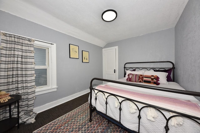 bedroom featuring a textured ceiling and vaulted ceiling