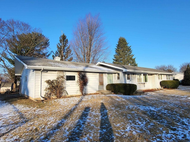 snow covered property with a garage