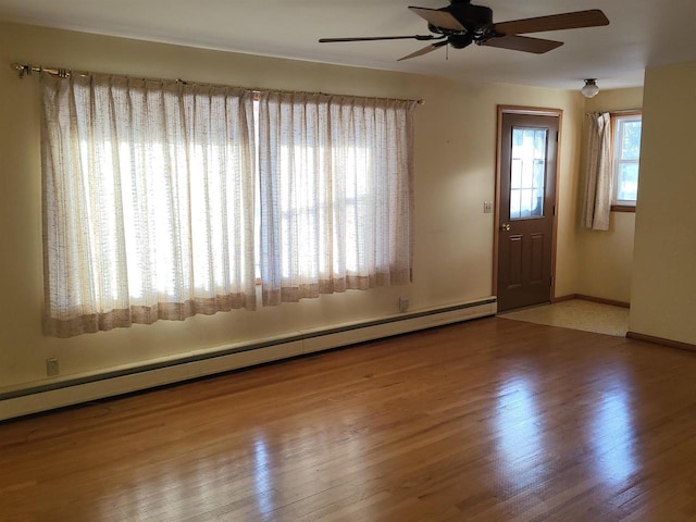 entryway with wood-type flooring, ceiling fan, and a baseboard heating unit