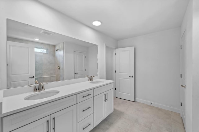 bathroom with a tile shower and vanity