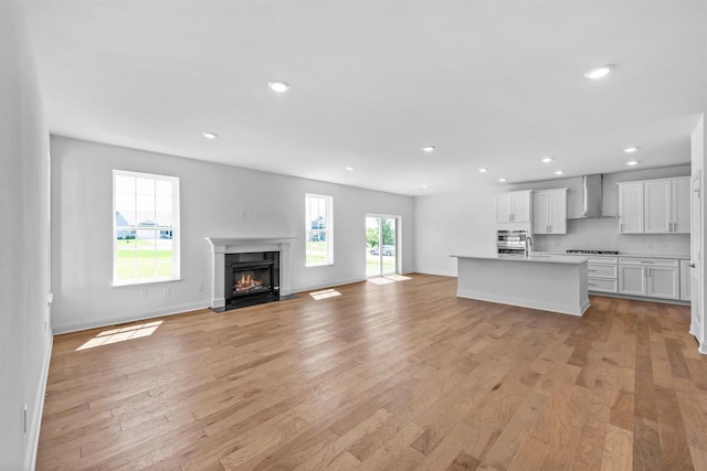 unfurnished living room featuring a high end fireplace and light hardwood / wood-style floors