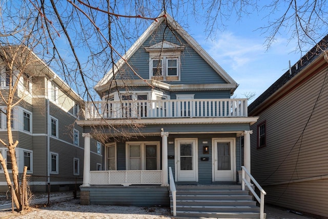 victorian house featuring covered porch and a balcony