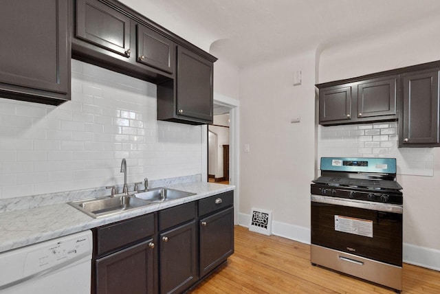 kitchen with gas stove, light hardwood / wood-style floors, sink, white dishwasher, and dark brown cabinets