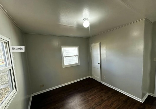 unfurnished room with a healthy amount of sunlight and dark wood-type flooring