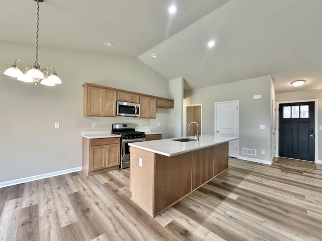 kitchen featuring decorative light fixtures, stainless steel appliances, an island with sink, a notable chandelier, and sink