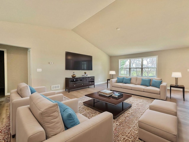 living room featuring lofted ceiling and light hardwood / wood-style flooring