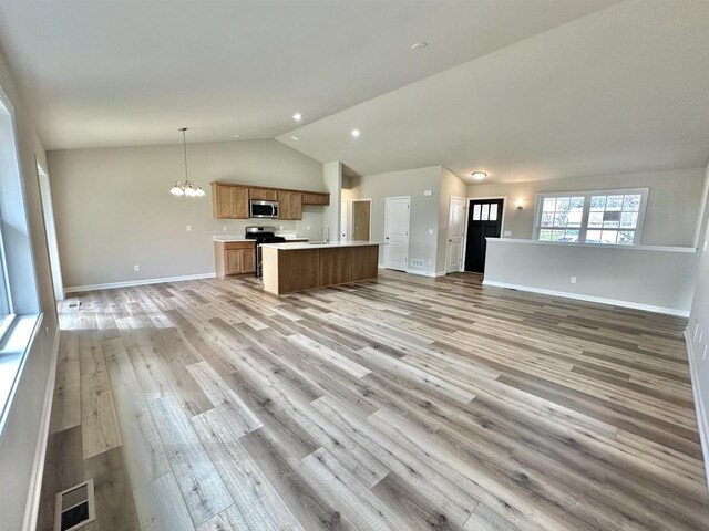 kitchen featuring stainless steel appliances, a notable chandelier, light hardwood / wood-style floors, and pendant lighting