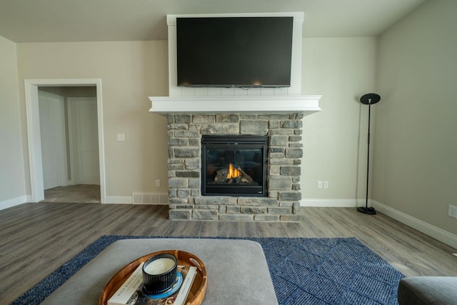 unfurnished living room featuring a fireplace and hardwood / wood-style flooring