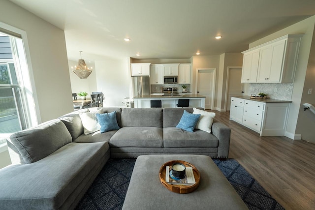 living room with sink, dark hardwood / wood-style floors, and a chandelier