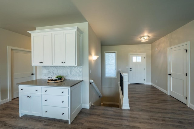 kitchen featuring white cabinetry, backsplash, and dark hardwood / wood-style floors