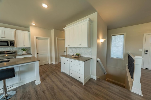 kitchen featuring stainless steel appliances, white cabinetry, and decorative backsplash