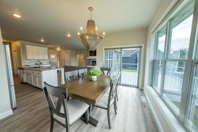 dining area with hardwood / wood-style flooring, an inviting chandelier, and sink