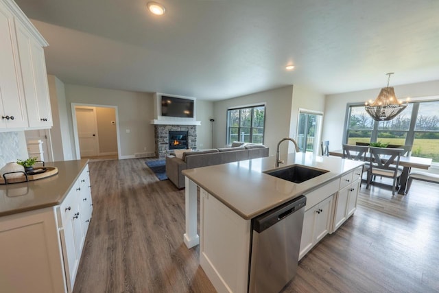 kitchen featuring white cabinets, a kitchen island with sink, stainless steel dishwasher, and sink