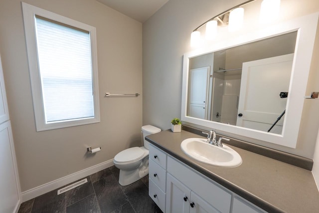 bathroom with walk in shower, vanity, and toilet