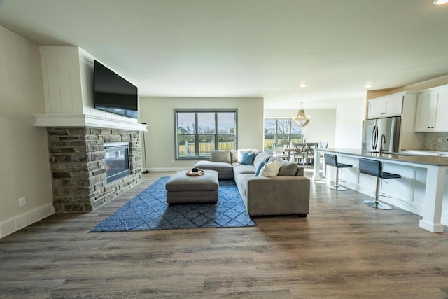 living room with dark hardwood / wood-style flooring and a fireplace