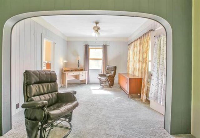 sitting room with crown molding and light carpet