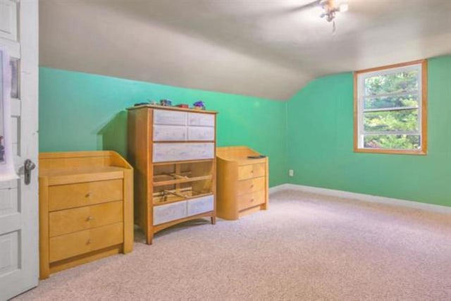 bonus room with lofted ceiling and carpet flooring