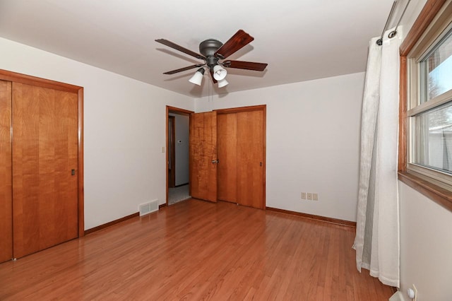 unfurnished bedroom with ceiling fan, multiple windows, and light hardwood / wood-style floors