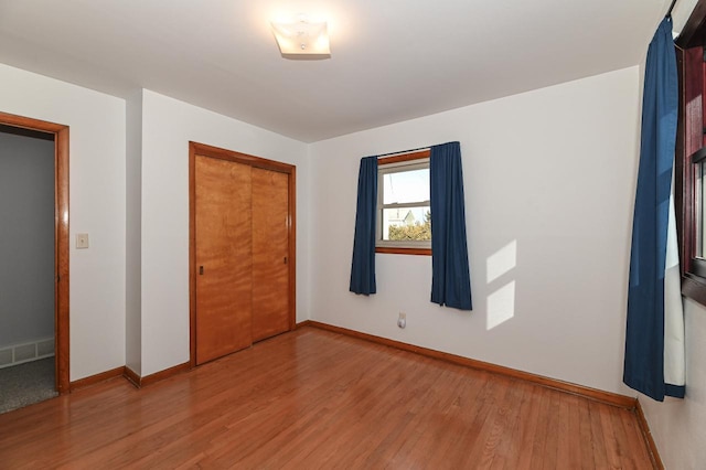 unfurnished bedroom with hardwood / wood-style flooring and a closet